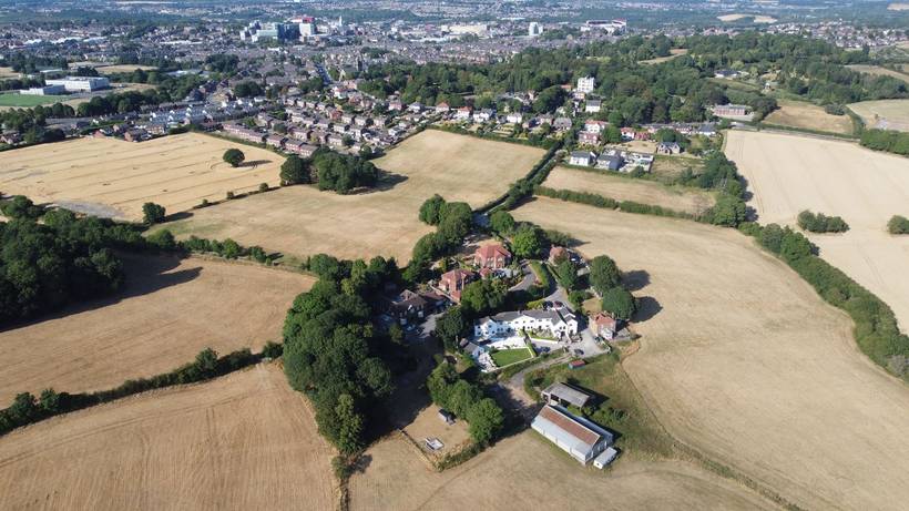 Aerial view looking north over harvested fields towards the town of Barnsley.